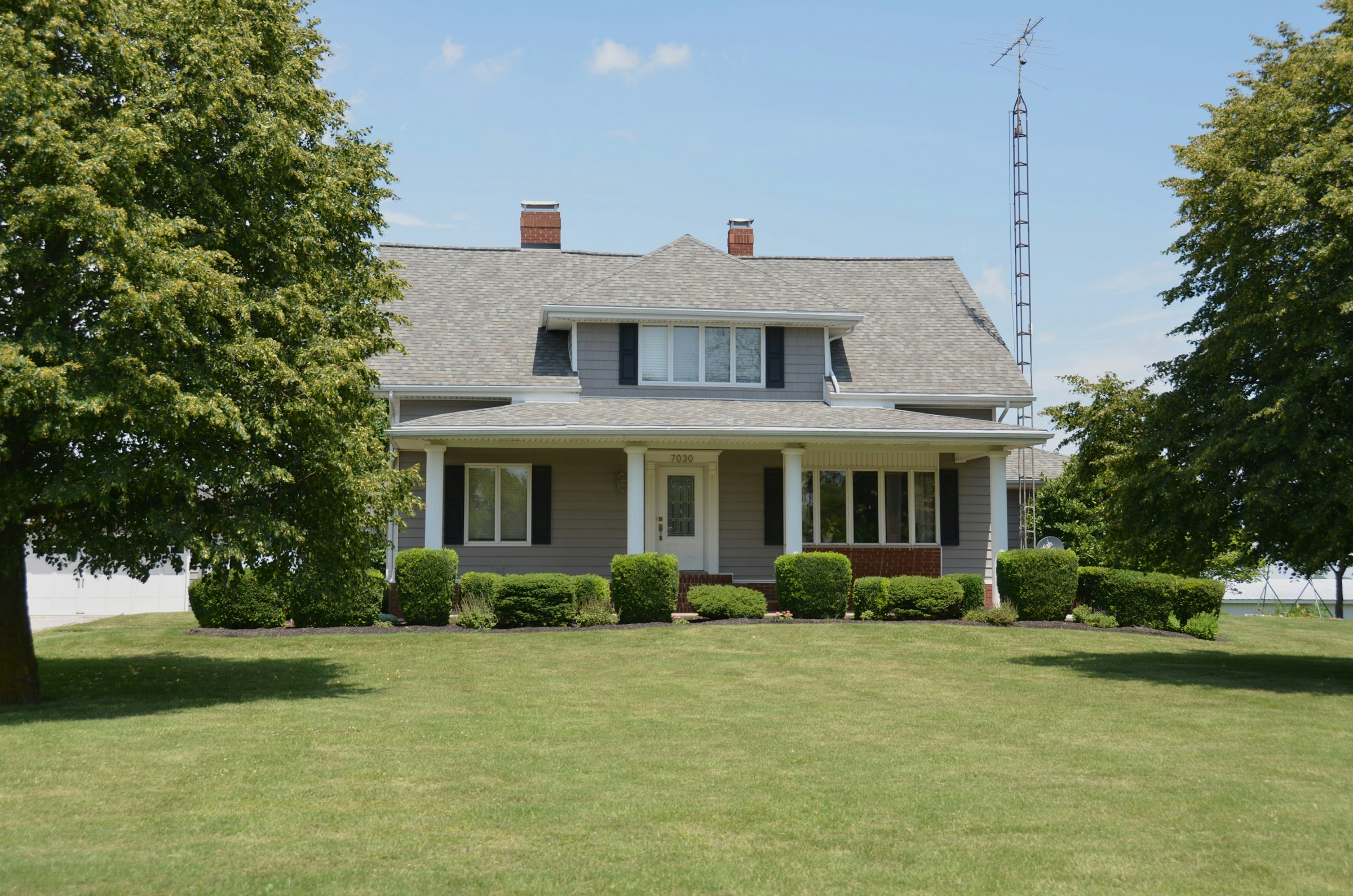 Two-story Michigan home with a covered front porch and green lawn